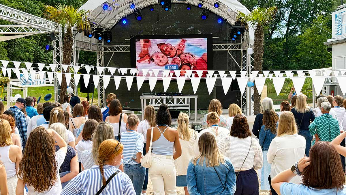 pme-Mitarbeitende der Region Hannover stehen vor einer Freilichtbühne