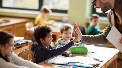 
		Lehrer gibt Schüler lachend High Five
	