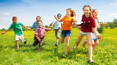 
		Kinder springen über eine grüne Wiese
	